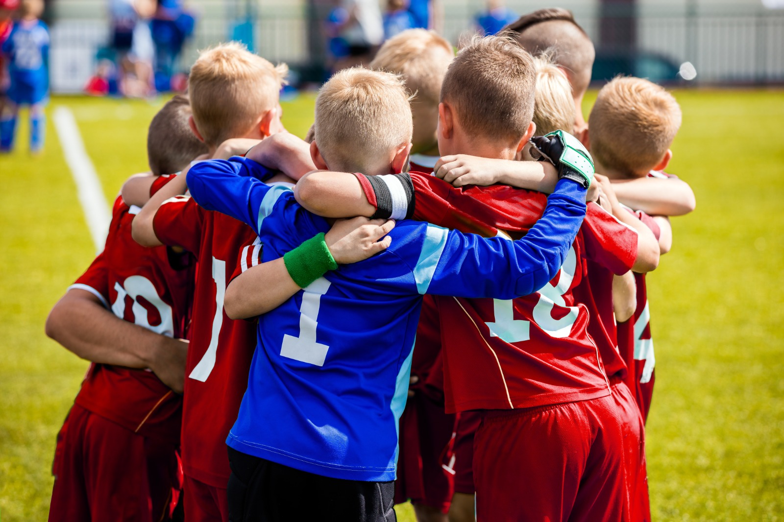 bambini che giocano a calcio si abbracciano